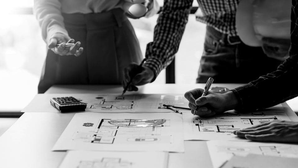 Hands marking up architectural floor plans