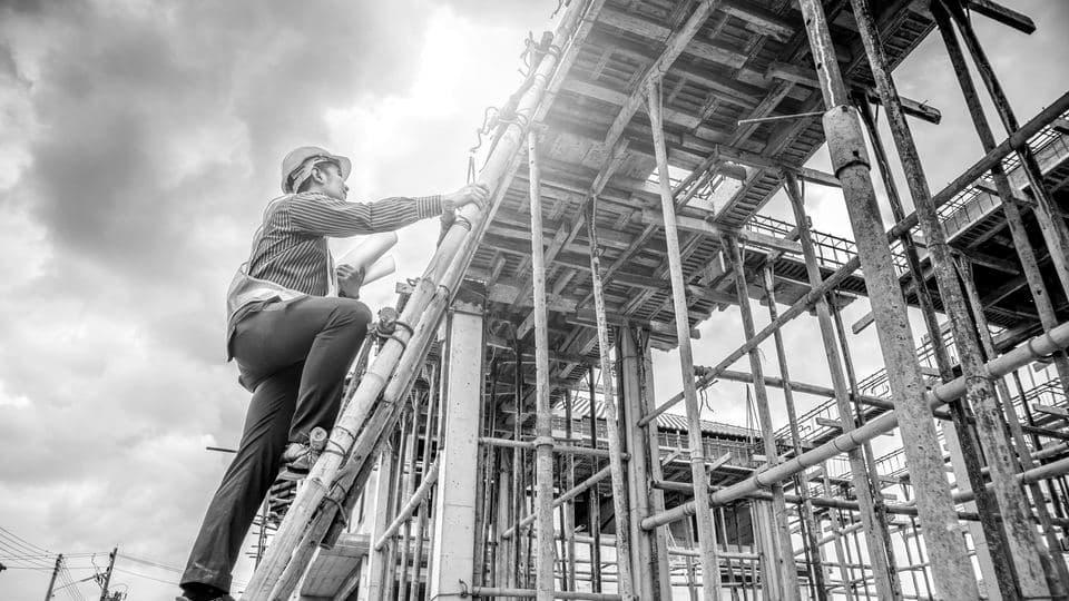 A worker climbing a structural frame on site